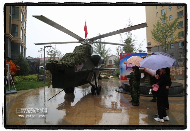 小區(qū)突然出現(xiàn)“飛機坦克”，其中殲15艦載戰(zhàn)斗機一架、99式主戰(zhàn)坦克一輛、武直-10武裝直升機一架，吸引了眾多市民雨中圍觀、合影。